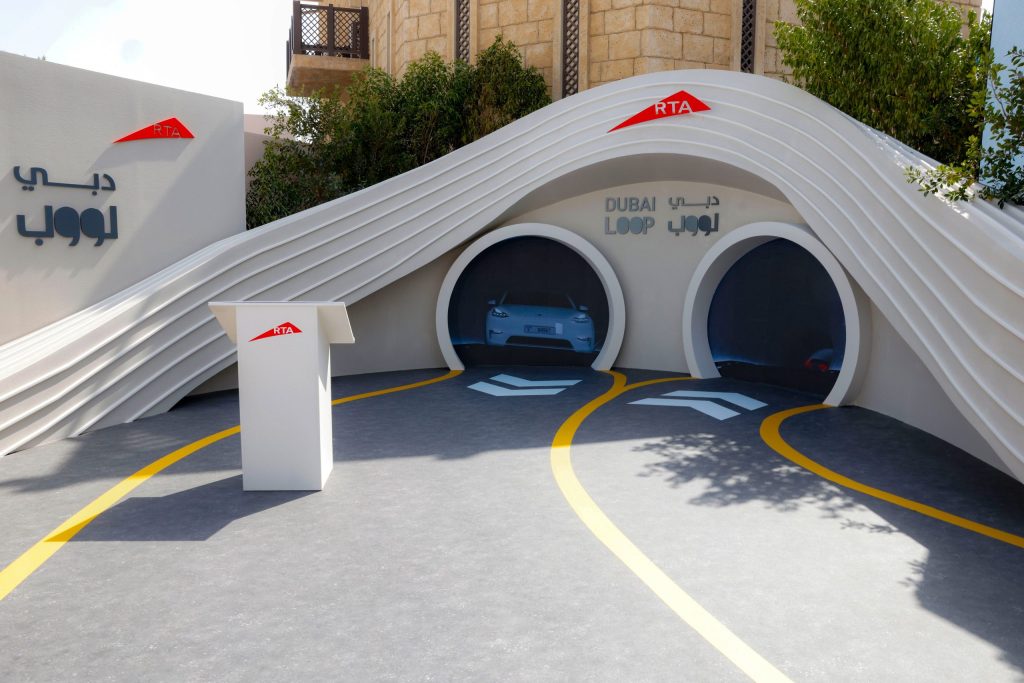 Dubai Loop RTA pavilion at the World Governments Summit 2026 — twin tunnel portals with a Tesla visible inside, RTA and Dubai Loop branding overhead